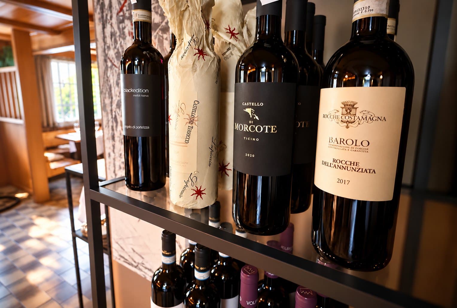 Flaschen Barolo und weitere italienische Rotweine im Weinregal